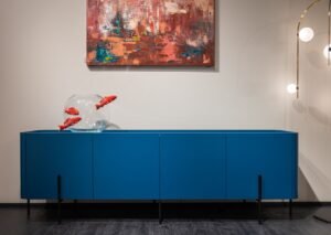 Acuario de cristal completo sobre mueble azul en un salón moderno