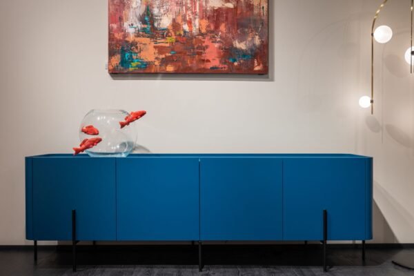 Acuario de cristal completo sobre mueble azul en un salón moderno